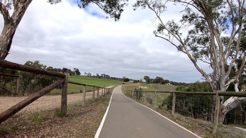 Amy Gillett Rail Trail between Mount Torrens and Charleston - a steep embankment falls away to the left while a farm track borders the east side of the bikeway